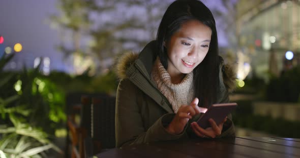 Woman using mobile phone at night alt