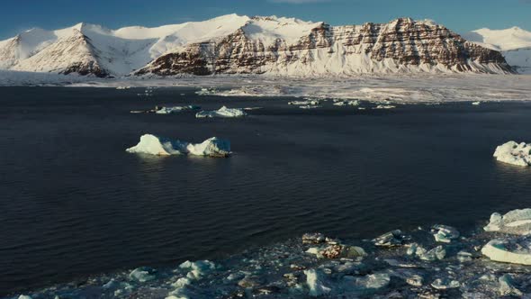 Aerial view of melting icebergs on lake at Jökulsárlón Glacier on Iceland during sunny day alt