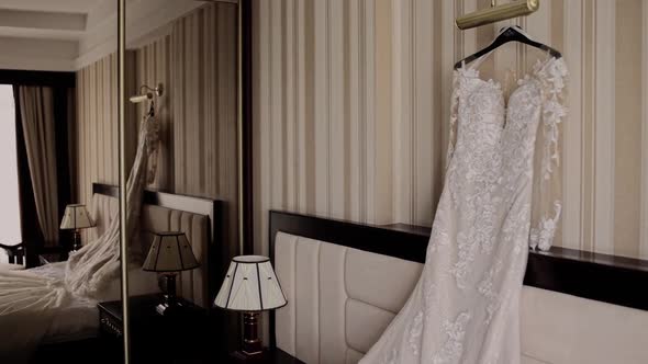 the bride's wedding dress is hanging in the room on the bed