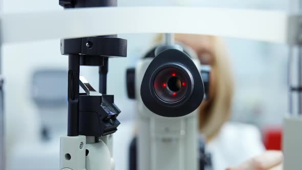 Patient checking vision with equipment. Doctor optometrist examining with special eye equipment alt