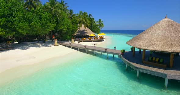 Aerial drone view of a tropical island dock pier over a beach alt