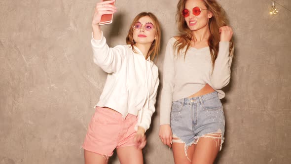 Two Carefree Young Girls Going Crazy. Women Dancing in Hipster Summer Jeans Shorts  alt