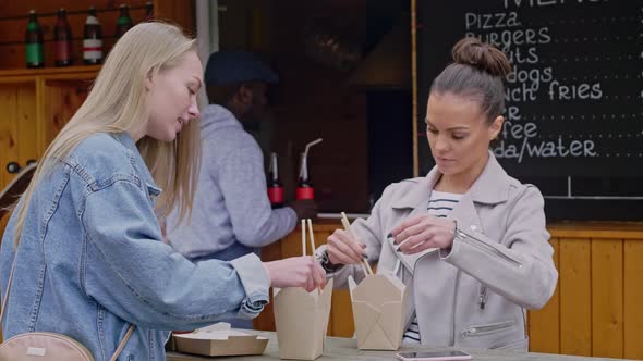 Caucasian girls trying street food