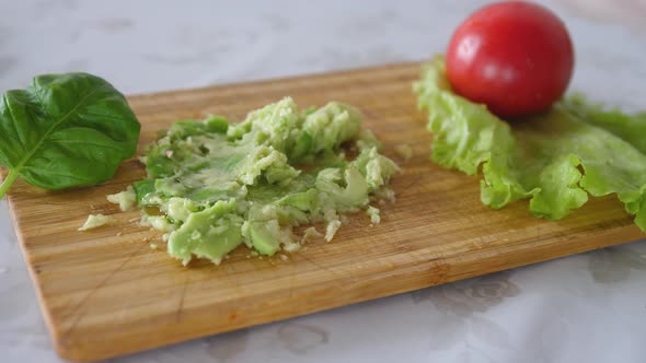 Peppering of Mashing Avocado with Black Pepper on a Board