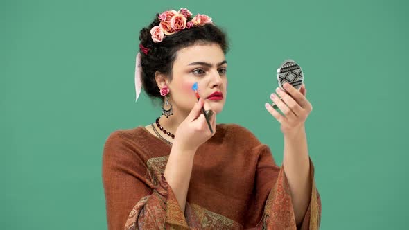 Portrait of Woman Style Icon and Famous Celebrity Frida Kahlo Painting Her Face with Brush and alt