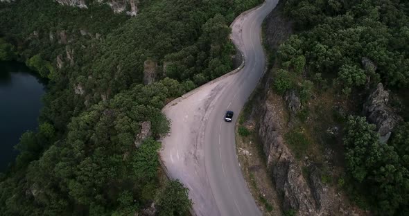 Aerial View of an Old Cabriolet Car Driving on a Country Road in the Forest
