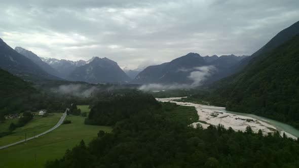 Aerial view of Soca river and car road surrounded by nature in Slovenia. alt