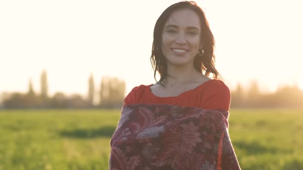 Portrait of a Beautiful Spanish Brunette Woman in a Red Dress at Sunset in a Wheat Field at Day alt