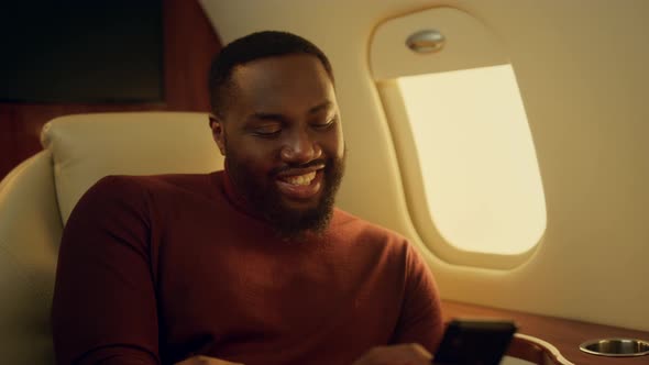 Cheerful Man Texting Friend at Plane Window Closeup alt