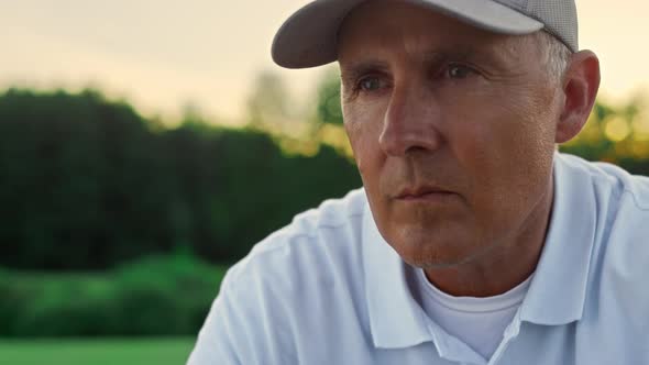 Old Sportsman Face Looking Distance on Sunset Field Course alt