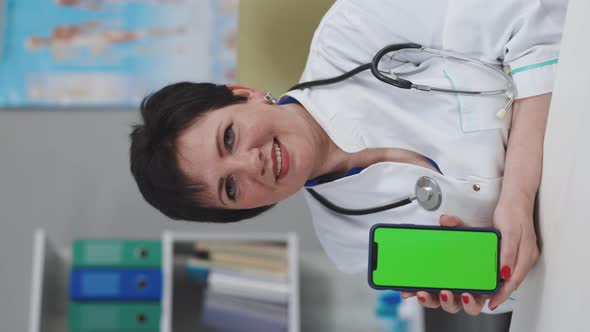 Vertical Video Medical Doctor Showing Test Results to a Patient on a Smartphone with Green Screen