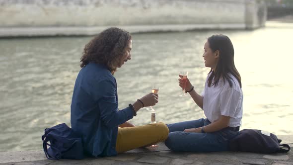 Couple in love drinking wine by the river