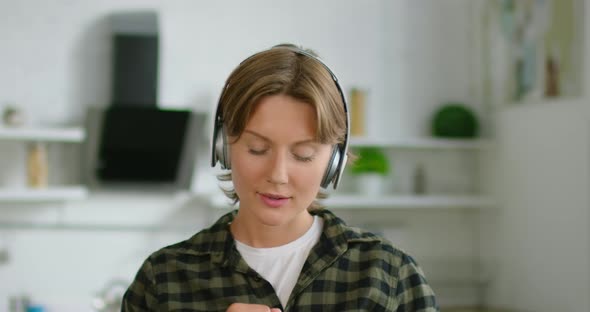Woman in Romantic Mood Is Listening Music in Wireless Headset, Close Up