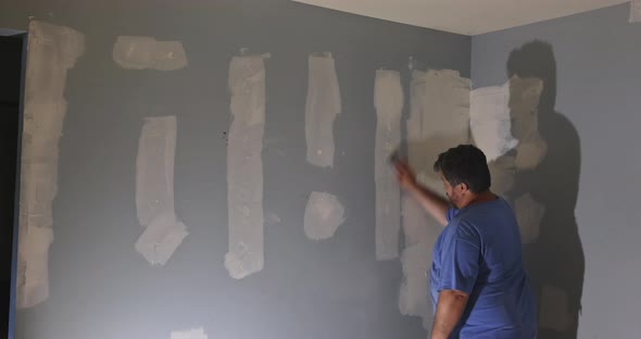 Contractor Using Sand Trowel Sanding the the Plaster Plasterboard alt