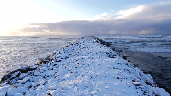 Iceland Moving Along Snow Covered Pier With Crashing Ocean Waves