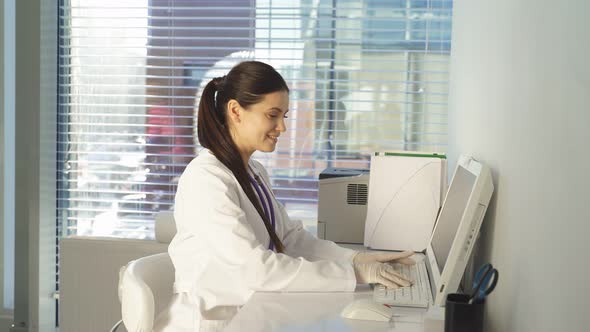 Portrait of Smiling Nice Female Pediatrician Sitting at Work Place