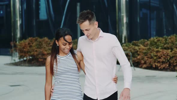 Beautiful Multiethnic Couple Hugging Talking and Walking Outside alt