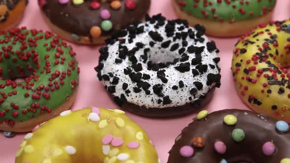 Assorted Donuts with Icing a Pink Background