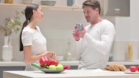 Mixed Race Couple Talking While Standing in Kitchen alt