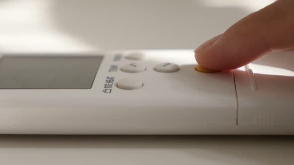 Pressing yellow power button on air conditioner remote control 4K 2160p UltraHD footage - Powering u alt