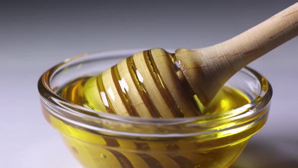 fresh golden honey pours beautifully from a wooden honey spoon alt