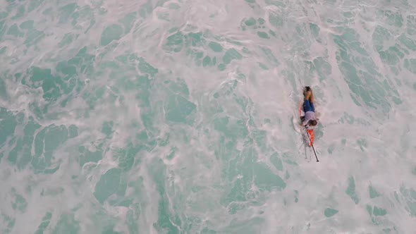 Aerial view of a man paddling while sup stand-up paddleboard surfing in Hawaii. alt