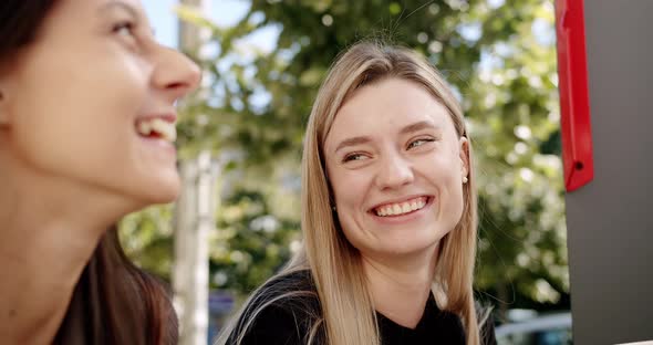 Two Women Enjoy a Conversation Looking at Each Other in Love Outside Summer alt