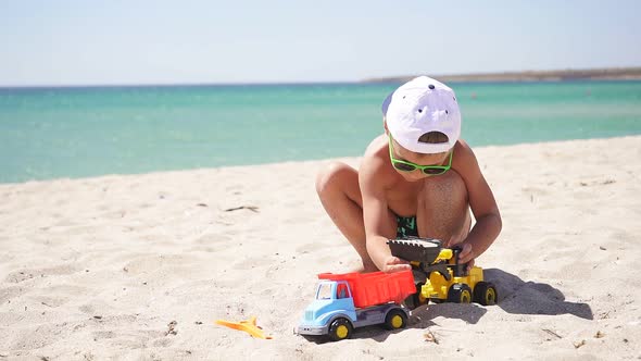 Sunny Summer Day Child Plays Toy Excavator Sandy Beach Azure Sea Blue Sky Horizon alt