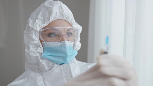 Closeup Portrait of Concentrated Caucasian Female Doctor Preparing Syringe with Drug alt