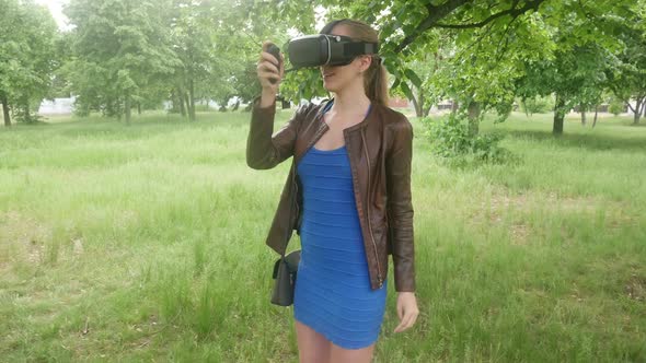 Sexy Beautiful Woman In A Virtual Reality Helmet Uses A Virtual App In The Park