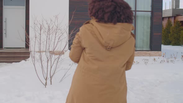 Happy African American Family Playing Snowballs Outdoors alt