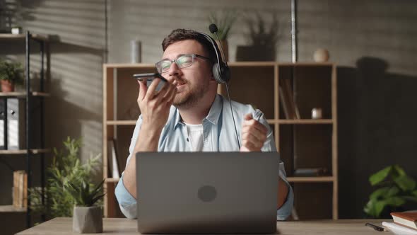 Happy Positive Young Man Wearing Headphones Singing Song Recording Audio Using Smartphone Voice alt