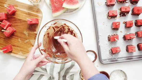 Step by step. Dipping watermelon cubes into melted chocolate and garnishing with sea salt and almond alt