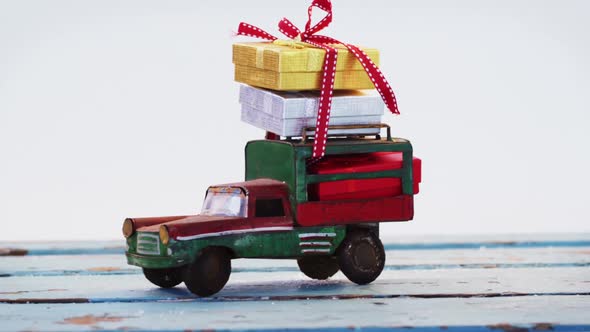 Toy tempo carrying christmas present on wooden plank alt