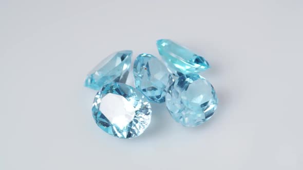 Natural Blue Topaz Gemstones on the White Background Turning Table