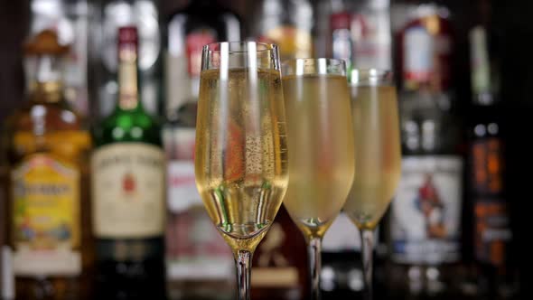 Closeup of Three Misted Glasses of Champagne Against the Background of a Bar alt