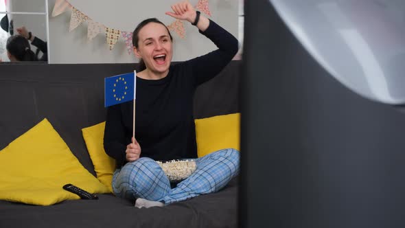 Woman Cheers While Watching Sports on TV at Home alt