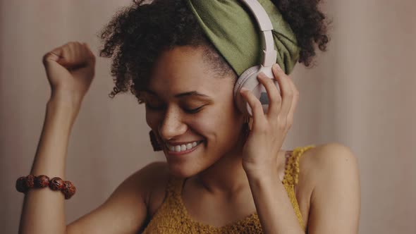 Close Up Portrait of Young Authentic Beautiful Stylish Black Woman Listening to Music Via Headphones alt