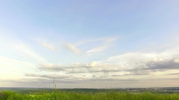 The motion of clouds on the background of the azure sky.