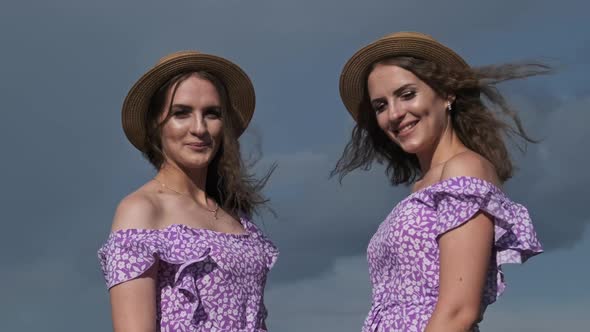 Portrait Two Young Twin Girls in Identical Dresses Looking in Camera in Nature alt