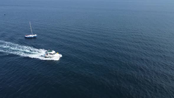 A white boat is racing at high speed on the waves of the blue sea. alt
