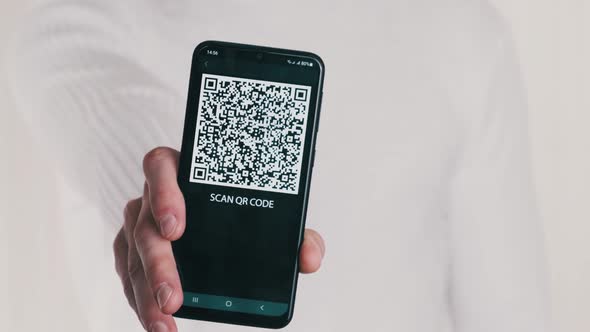 Male Hand Shows QR Code on Smartphone on White Background alt