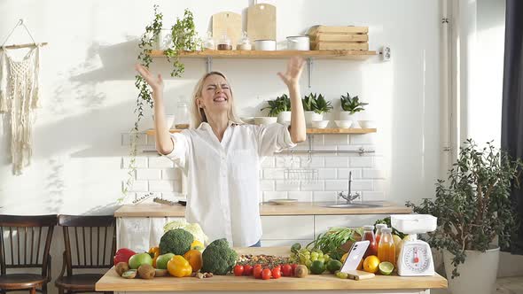 Happy Female Blogger is Going to Make a Salad of Fresh Vegetables in Her Kitchen at Home and Records