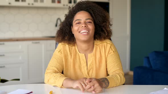 Beautiful Young Curly African Ethnicity Woman Looking at the Camera and Waving alt