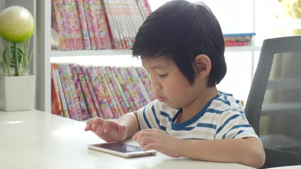 Happy Asian Child Using Mobile Phone On White Table
