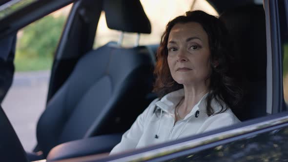 Portrait of Confident Mature Caucasian Woman Posing on Driver's Seat As Graduate Daughter Sitting in alt