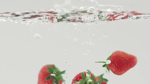 Delicious Strawberry Falling Into Water in Slow Motion Beautiful Commercial Shot alt