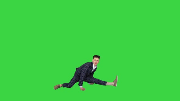 Young Attractive Male Dancer in the Strict Business Suit Dancing Making a Split on a Green Screen alt