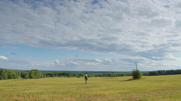 Farmer Walking in Mown Field alt