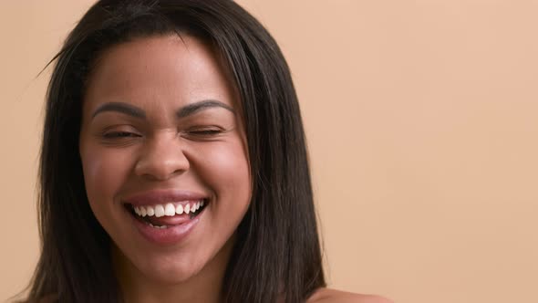 Black Woman Posing Smiling And Sticking Out Tongue Beige Background alt